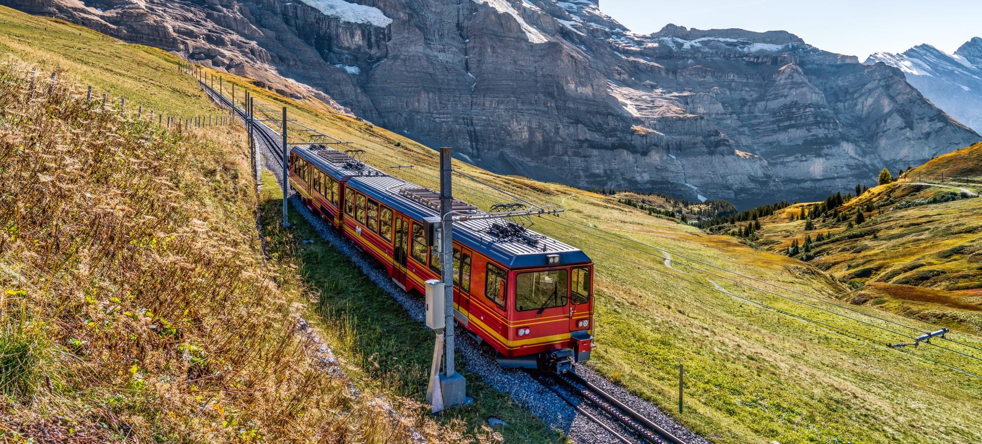 The red train running on the Jungfrau railway with a background view of Jungfrau